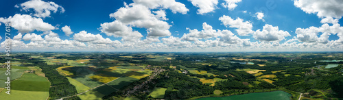 A beautiful panorama from the air of a blue sky with clouds and from below a town among green fields. beautiful panorama of Arges county landscape in spring. France. Aerial. Drone 4k. 