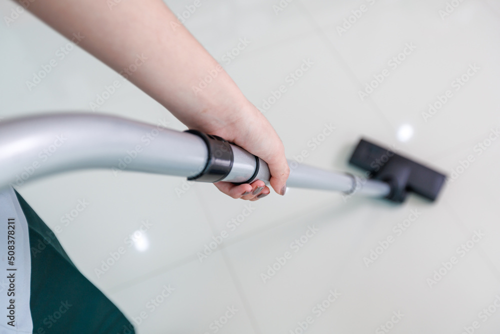 Young woman using vacuum cleaner