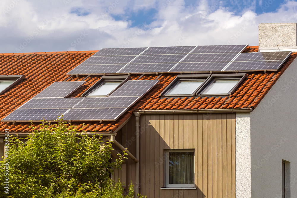 Solar Panel station on private House Roof. Solar panels on tiled roof with windows. Solar Panel station on private House Roof. Solar panels on tiled roof with windows.