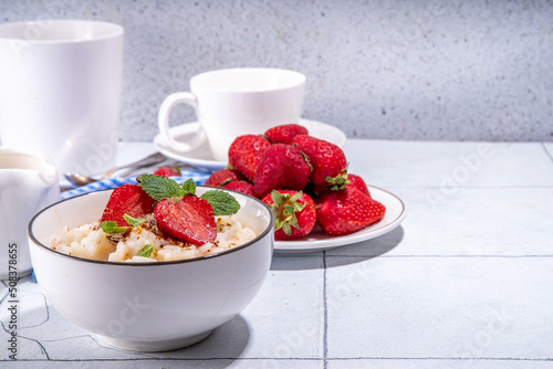 Obraz na plátne Rice porridge or pudding with fresh strawberry and nuts for breakfast, with plat