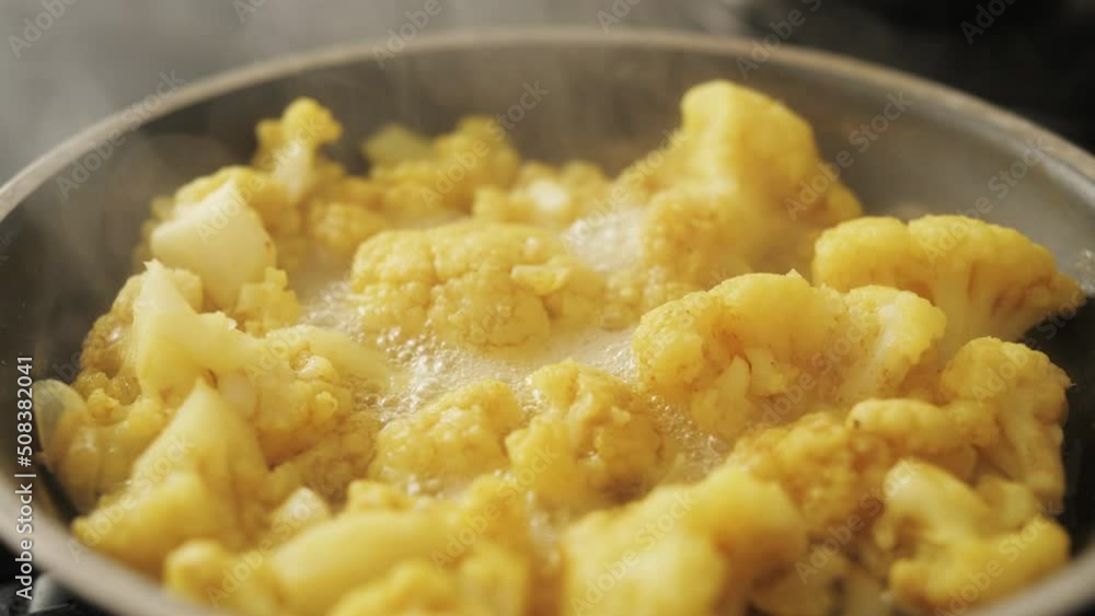 Cauliflower fried in pan close up shot. Vegan cuisine, cauliflower recipe. Homemade dish. Healthy food concept. Cauliflower fried in pan close up shot. Vegan cuisine, cauliflower recipe. Homemade dish. Healthy food concept.