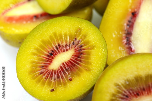 fresh red kiwi fruit and a cut one on a white background