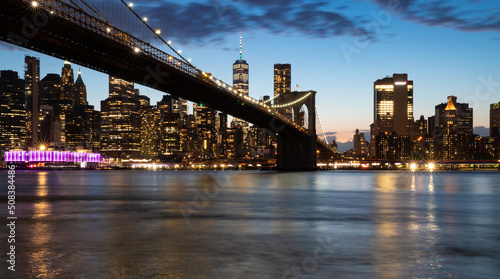 Fototapeta Naklejka Na Ścianę i Meble -  vue panoramique en pause longue sur Manhattan et le pont de Brooklyn le soir juste avant la nuit. Buildings et skyline illuminés