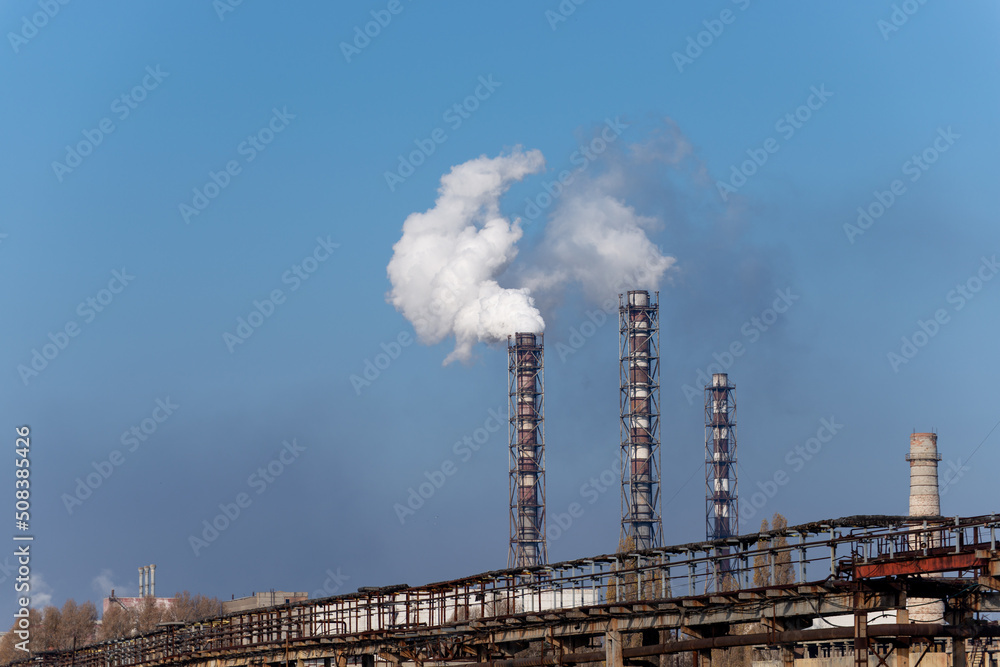 Smoke stack of coal power plant on blue sky background.