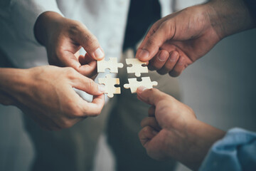 Concept of teamwork and partnership. Hands join puzzle pieces in the office. business people putting the jigsaws team together.Charity, volunteer. Unity, team business.