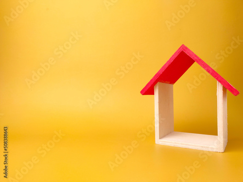 Toy house isolated on yellow background with copy space