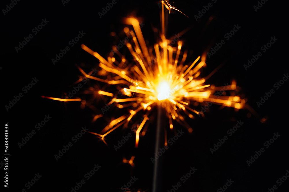 Close view of sparkler on black background. soft selective focus. abstract bokeh background, copy space. Christmas or New Year composition. Christmas card.