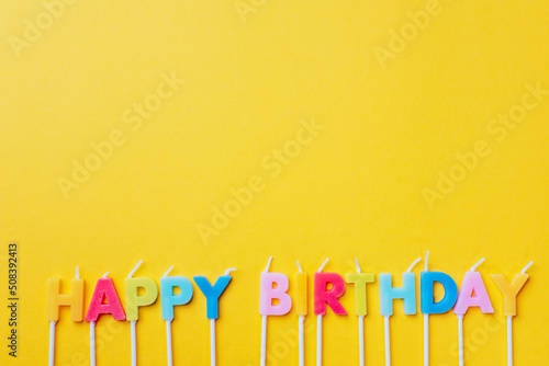 Canvas Print party background with text Happy Birthday by colorful candles on orange backround