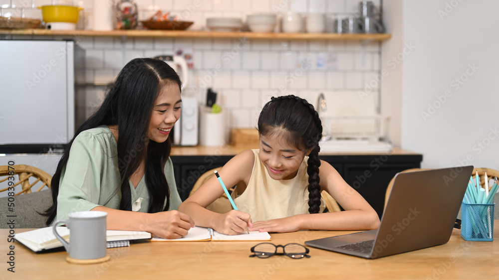 Asian mom helping her daughter doing homework. Concept of Virtual education, homeschooling Asian mom helping her daughter doing homework. Concept of Virtual education, homeschooling