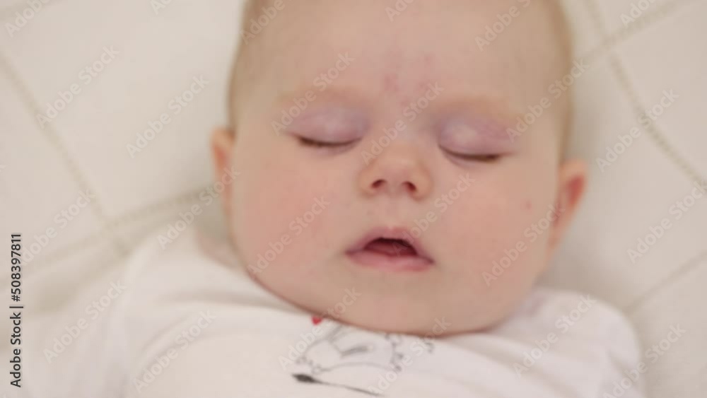 Peaceful adorable baby sleeping on his bed in a room at home. Soft focus. Sleeping baby concept. Six month old babygirl sleeps at home, top view Peaceful adorable baby sleeping on his bed in a room at home. Soft focus. Sleeping baby concept. Six month old babygirl sleeps at home, top view