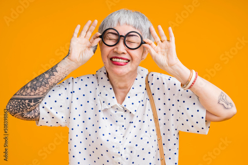 Fotografie Portrait of attractive funky asian tattoo cheerful grey-haired elder old senior