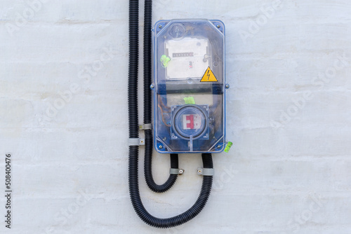 Domestic digital electricity meter in transparent case, mounted on wall