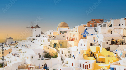 Banner travel in Santorini, Greece. Picturesq view of sunset sky scene traditional cycladic Santorini houses  blue background © SASITHORN