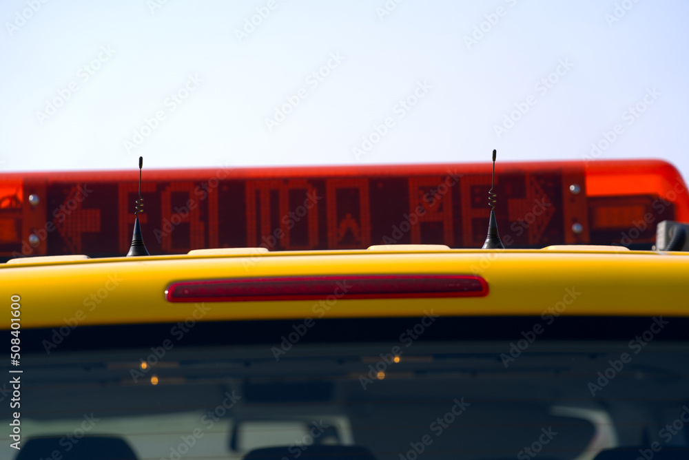 Fototapeta premium Close-up of roof top with follow me display of parked yellow van of airfield maintenance at Zürich Airport on a sunny spring day. Photo taken March 26th, 2022, Zurich, Switzerland.