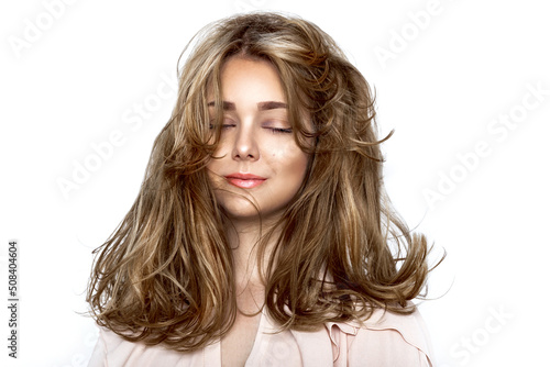 Portrait of a beautiful natural girl with beautiful healthy hair on a white background. A beautiful young girl with a perfect face and beautiful flowing hair. Beauty hair - concept.