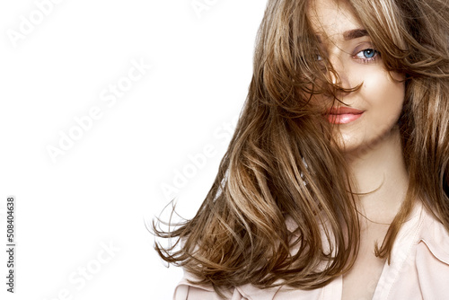 Portrait of a beautiful natural girl with beautiful healthy hair on a white background. A beautiful young girl with a perfect face and beautiful flowing hair. Beauty hair - concept.