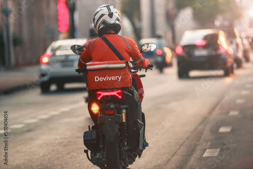A food delivery driver is driving deliveries to customers ordering food online in a busy capital city, Impact of epidemics