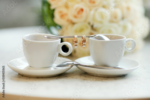 Bride and groom's Coffee time, coffee break.Cups and rings on teaspoon photo