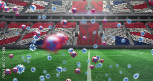 Image of covid 19 cells over british flag in empty sports stadium