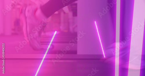 Image of glowing pink lights over athlete running on treadmill in gym