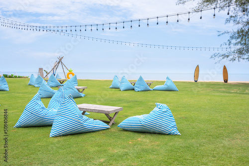 Bean bag seats to relax on grass outdoors On the beach, overlooking the sea.
