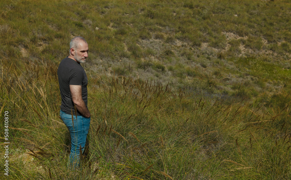 Adult man standing on grass in mountain