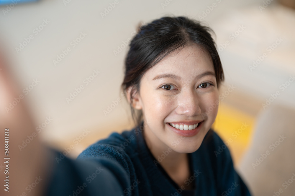 Image of attractive young asian woman make selfie by camera at her home Image of attractive young asian woman make selfie by camera at her home
