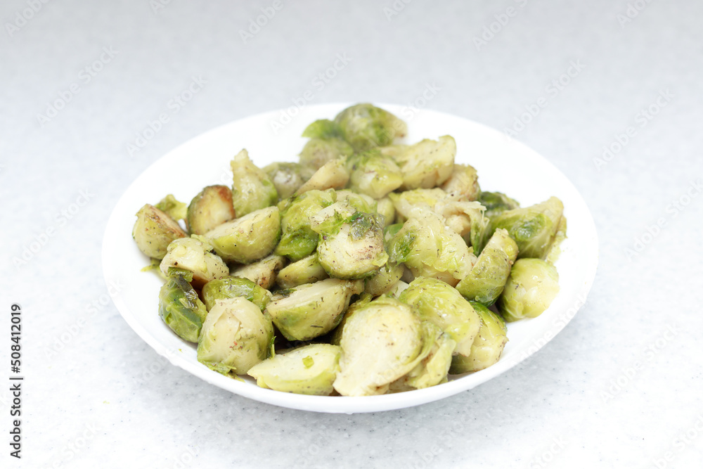 Grilled Brussels sprouts with spices on a white plate. Grilled Brussels sprouts with spices on a white plate.