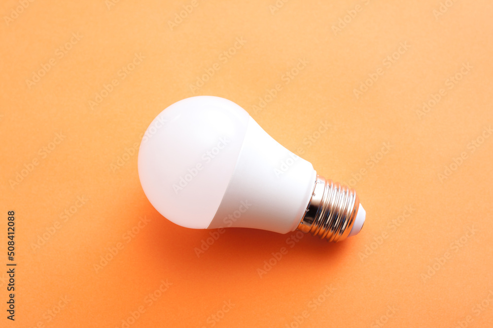 White economy light bulb on orange background. White economy light bulb on orange background.