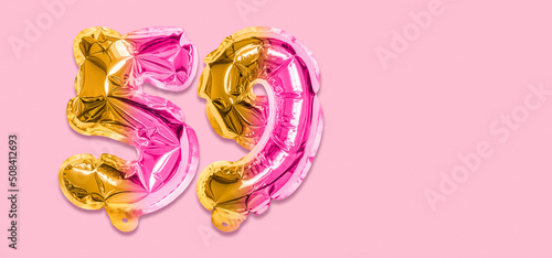 Rainbow foil balloon number, digit fifty nine on a pink background. Birthday greeting card with inscription 59. Top view. Numerical digit. Celebration event, template. Banner photo