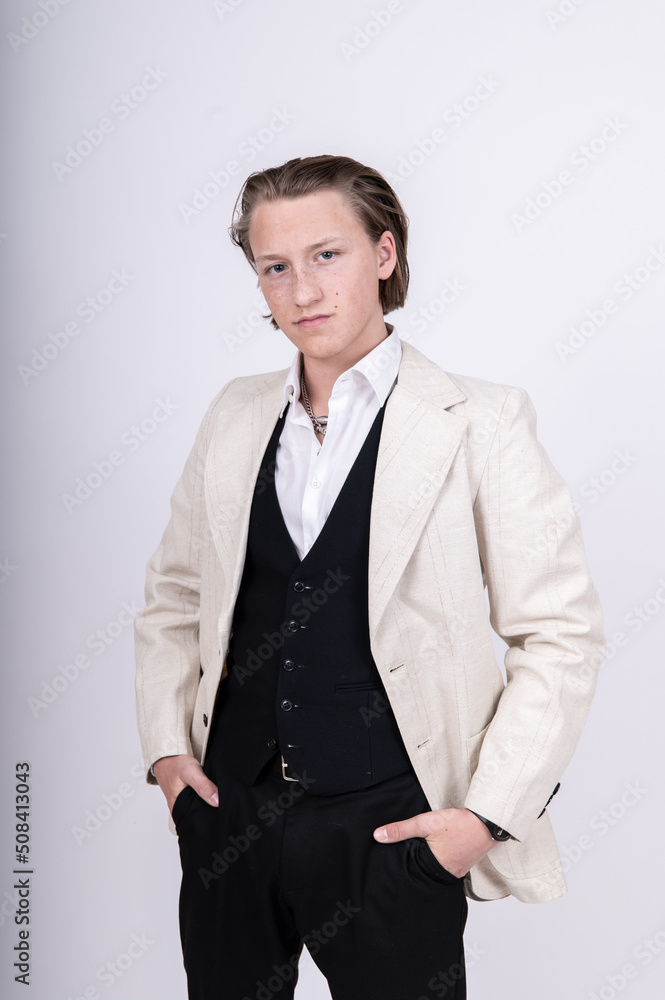 Porträt junger Mann mit langen Haaren lässig mit schwarzem Gilet und heller Jacke