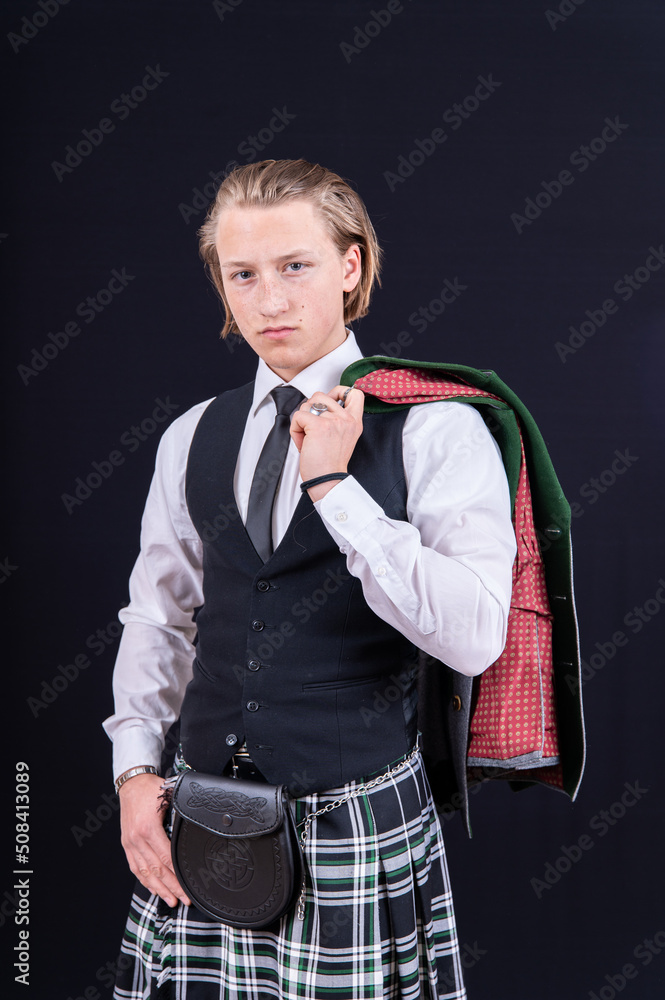 Porträt junger Mann mit langen Haaren im Kilt jacke lässig über die Schulter geworfen