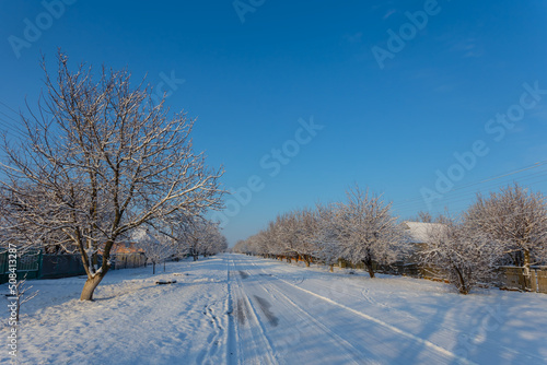 small village street in snow, early morning rural winter scene