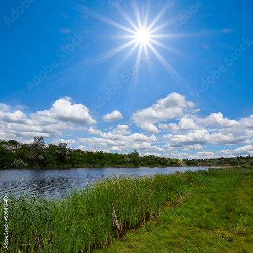 small calm river among green fields at summer sunny day, beautiful countryside landscape