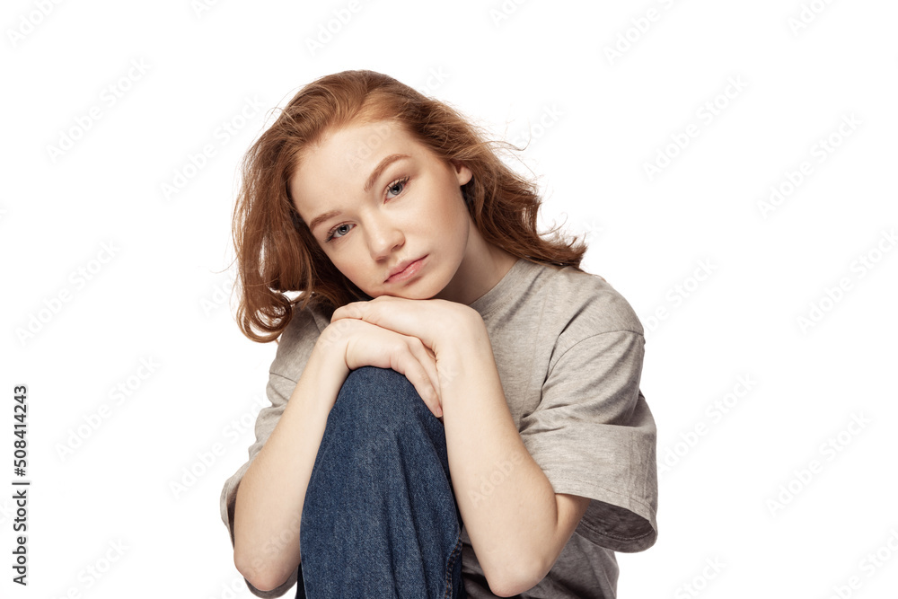 Pretty redhead young girl with long curly hair looking at camera with light smile isolated on white background. Concept of youth, beauty, lifestyle Pretty redhead young girl with long curly hair looking at camera with light smile isolated on white background. Concept of youth, beauty, lifestyle