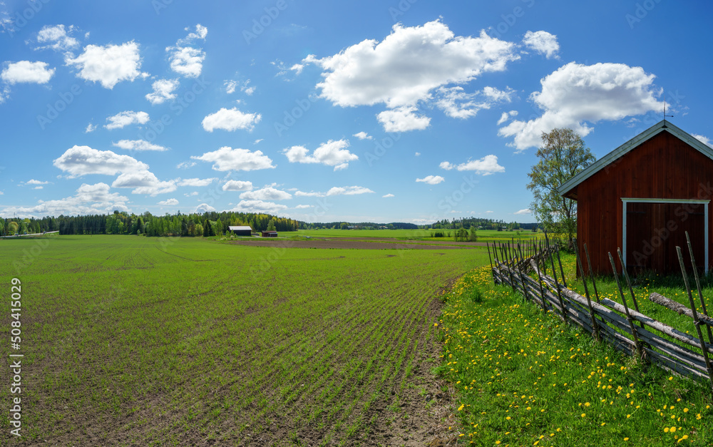 Rural landscape on a beautiful spring day in Rusko, Finland. A traditional Finnish roundpole fence runs around the old barn. Rural landscape on a beautiful spring day in Rusko, Finland. A traditional Finnish roundpole fence runs around the old barn.