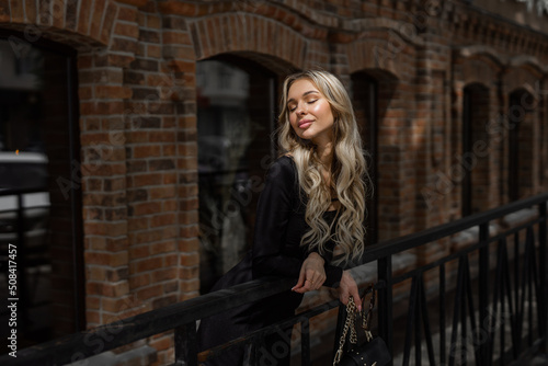 portrait of a beautiful young woman in a black dress on a walk 