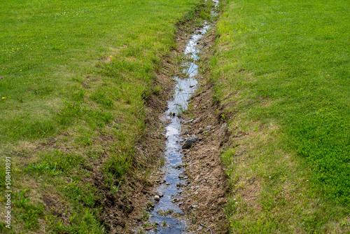 Drainage ditch in a meadow photo