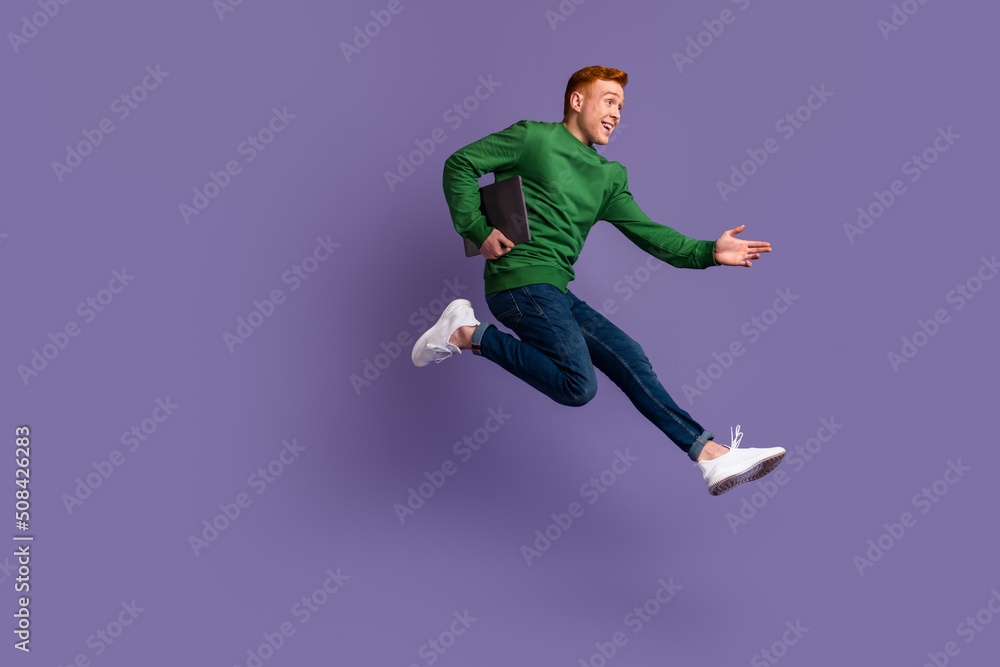 Full size profile side photo of young man run jump hold laptop agent marketer isolated over violet color background