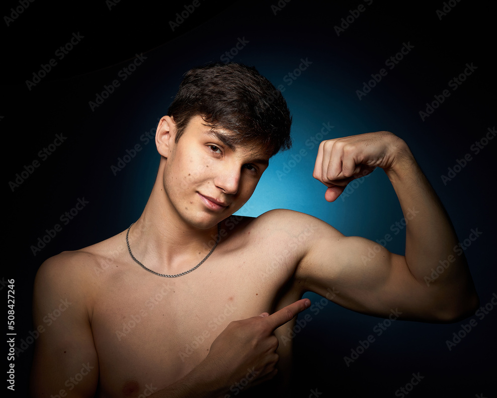 a healthy athletic teenager shows off his body against a dark background, the concept of proper nutrition