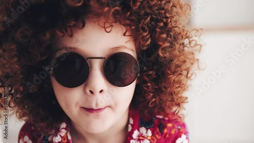 facial portrait of redhead curly kid in sunglasses photo