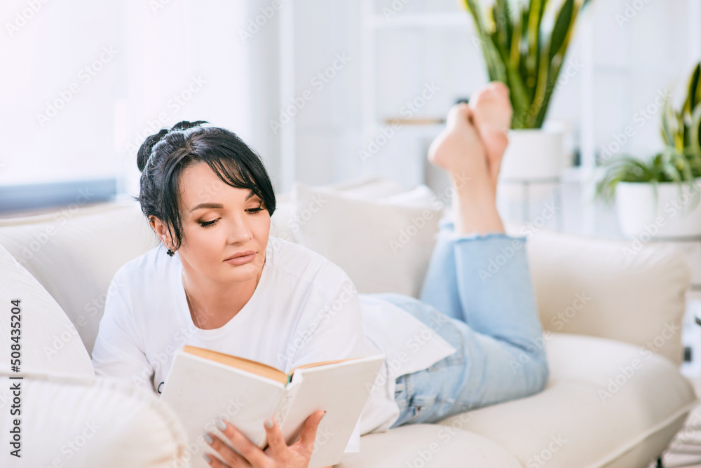 beautiful woman on the sofa reading book. Free time, education, self development concept. beautiful woman on the sofa reading book. Free time, education, self development concept.