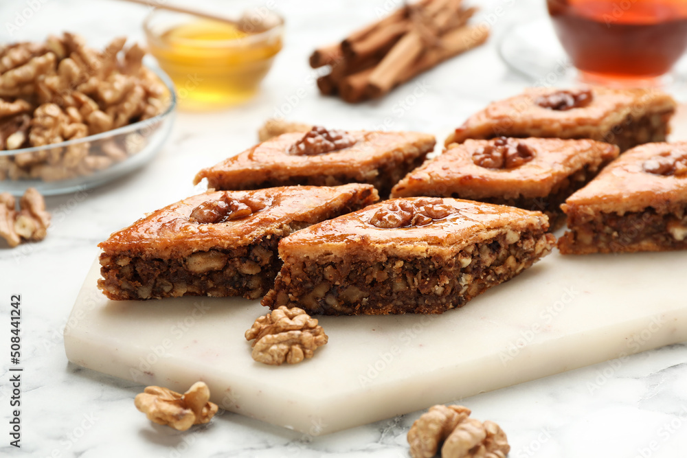 Delicious honey baklava with walnuts on served white marble table, closeup Delicious honey baklava with walnuts on served white marble table, closeup