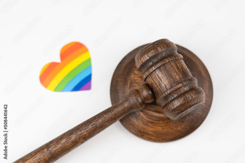 Judicial gavel and heart with rainbow flag on a white background. Protecting the rights of homosexuals in court. Judicial gavel and heart with rainbow flag on a white background. Protecting the rights of homosexuals in court.