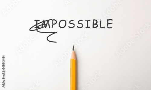 Tableau sur toile Word IMPOSSIBLE with crossed out letters IM and pencil on white background, top view