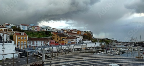 Rainy day with a rainbow in a small town with orange roofs in the Azores