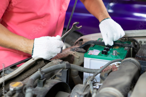 Closeup mechanic fixes car engine, wears gloves and wrench. Check or inspect old car engine for long driving. Concept : auto engine maintenance service. 