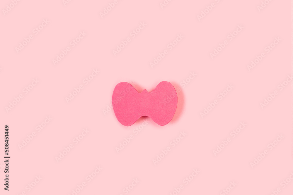 Glándula tiroides en papel sobre un fondo rosa liso y aislado. Vista superior. Copy space. Concepto: Día Mundial de la Tiroides.  Problemas con la tiroides. Dia mundial contra el cancer
 - obrazy, fototapety, plakaty 