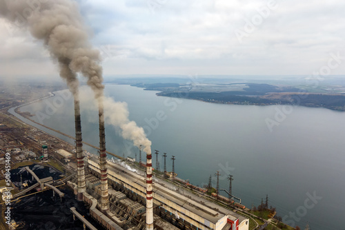 Aerial view of coal power plant high pipes with black smoke moving up polluting atmosphere