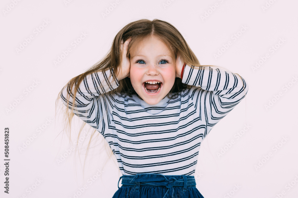 Portrait of little girl holding hands on head, screaming with opened mouth and crazy expression. Surprised or shocked face Portrait of little girl holding hands on head, screaming with opened mouth and crazy expression. Surprised or shocked face